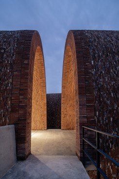 Light slots are reserved on the drainage ditch between the arch wall and ground. The warm lighting infuses the lower wall to create a welcoming atmosphere.