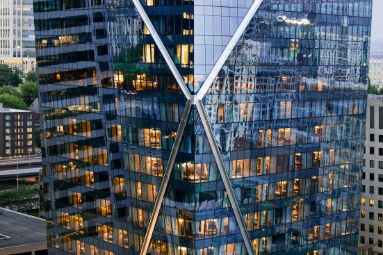 Behind stainless steel cladding, custom knuckles made of structural steel join four incoming diagonal members.