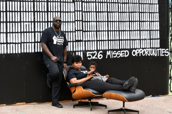 Michael Ford and his family in front of his mural "526 Missed Opportunities," in Madison, Wis.