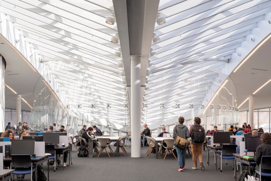 Linear and canopy-mounted light fixtures reinforce the arch form of the library skylight.