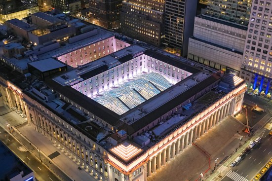 The train hall and mid-block connector skylights shine from above, showcasing the phased implementation of façade lighting. Inside-facing façades are washed, increasing transparency from within.