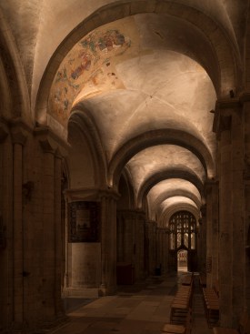 The side aisles feature painted medieval artworks, revealed by fixtures located on column capitals.