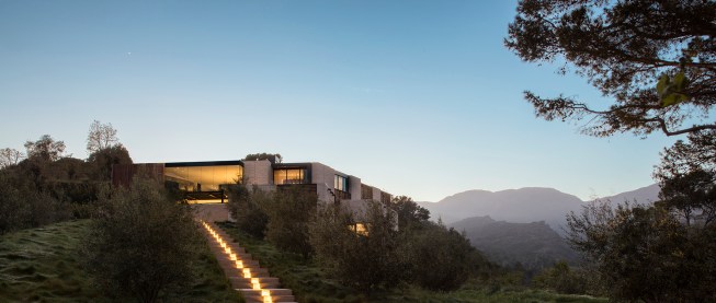 Lighting integrated into the water runnel leads the eye to the residence.