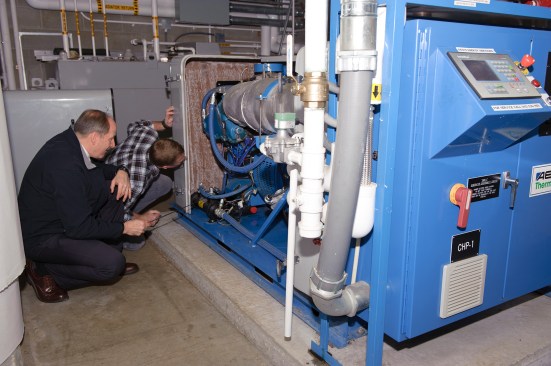 A.J. Ballard, the energy manager for the Maine Army National Guard, points out some of the engine details of the award-winning combined heat and power system at the Maine Army National Guard Army Aviation Support Facility in Bangor, Maine. Photo by Staff Sgt. Angela Parady.