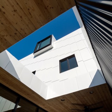 PAC-CLAD Corrugated Wall System in black and custom-fabricated Flat Seam Panels in white PAC-CLAD aluminum.
