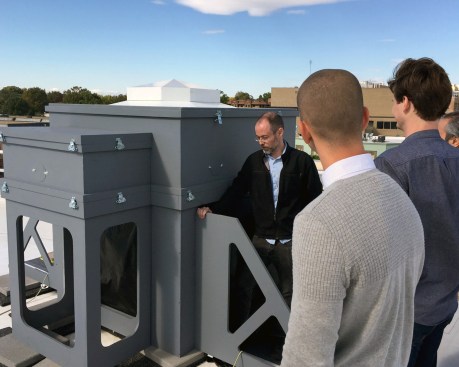 George Sexton Associates lighting designer Owen Brady stands beside a small-scale daylight model of the Rothko Chapel skylight on the roof of GSA's Washington, D.C., office in 2019.