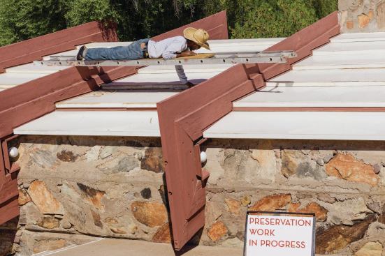 A maintenance worker removes deteriorated sealant from the acrylic panels that top the controversial canvas roofs over the historc core of Taliesin West, to 10-acre compound designed by Frank Lloyd Wright.