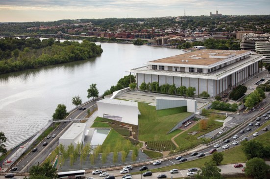 Aerial view of The Reach, with the original Kennedy Center building designed by Edward Durell Stone beyond. The new concrete pavilions were cast in place using formwork lined with 4-inch boards. Titanium was added to the concrete mix to help achieve a white that nods to the marble on the Stone building. A grove of 35 ginkgo trees anchors the south end of the site, representing John F. Kennedy as the 35th president of the United States.