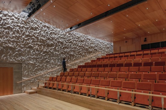 n performance spaces such as the Justice Forum (which is the only space with raked seating), the orthogonal interior walls are covered in what looks like crumpled paper, but is in fact structural concrete with a cast-in texture. Working with an acoustical engineer, the team determined that a varied surface with a 2-inch depth would be optimal. This innovation, dubbed “crinkle concrete,” scatters sound waves, tuning the space for a variety of performance types. But because the texture can’t meet at right angles like a smooth surface, it required extra corner detailing for the formwork in rooms that feature it on more than one wall.