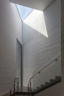 The spaces below The Reach’s green roof are connected via a series of bridges, hallways, and stairs—like this one from the upper level to the lower level which is lit by a skylight embedded in the lawn; the window (at left) opens onto one of the performance spaces. 