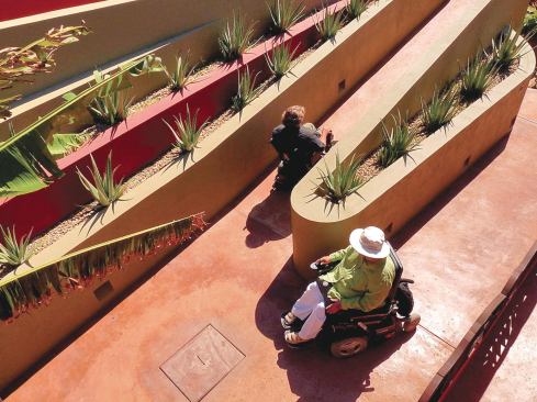 A concrete wheelchair-accessible ramp leads to the main living spaces on the second floor.