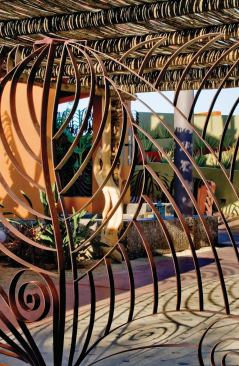 Shadows cast by the ironwork's seashell and wave motifs animate the ground plane.