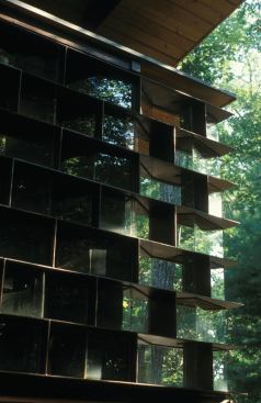 The HoneyHouse ingeniously uses a steel-and-glass wall of shelves to bring in light, provide structural support, and store and display honey.