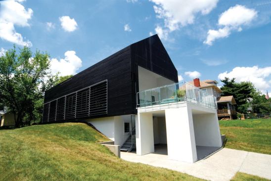 The south face of Studio 804's Prescott Passive House (at left) feature louvers to mediate solar heat gain. The operable triple-pane insulated glazing behind them is part of a natural ventilation system that includes skylights on the north side. A white metal roof helps keep the house cool during spring and summer, when the sun is high in the sky, while a charred Douglas fir façade absorbs warming UV rays in fall and winter.