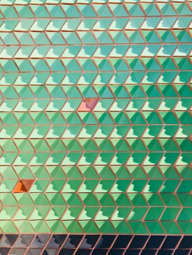 A closeup of Tolila + Gilliland's façade of glazed terra-cotta tiles.