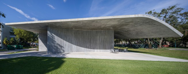 West façade with curved concrete wall concealing entry
